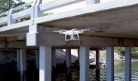 Drone hovering under a bridge