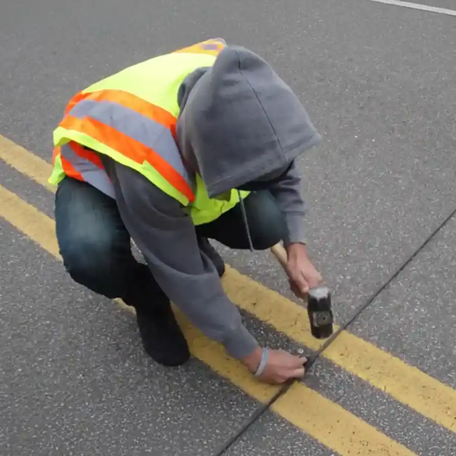 Image of a road worker repairing tubes on a road